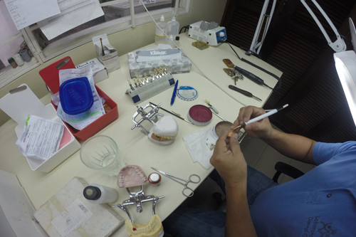 Persona fabricando piezas dentales en el laboratorio